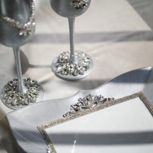 Close-up detail of Majestic Classic luxury wedding set showing silver crystal-embellished champagne flutes and handpainted silver plate with crystal fork accents