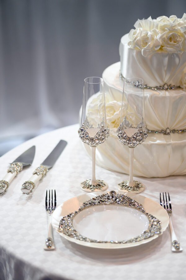 Complete Ethereal collection wedding set with crystal champagne flutes, dinner plate, cake cutting set, and tiered wedding cake